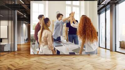 Students in class, two teens girl and guy are giving five each other another classmates looking at them standing near. Carefree student life. Education, studying in highschool, college, university. Wall mural