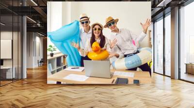 Team of happy, excited corporate employees going on summer vacation travel together. Group of three cheerful, funny people, ready for holiday, having fun with beach toys and water mattress in office Wall mural