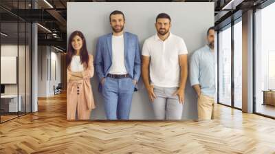 Team of happy smiling business people standing against grey studio background. Banner with group portrait of confident successful senior and young men and women in smart and casual clothes Wall mural