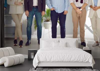 Team of people in smart casual clothes at work in office. Group of men and women in shirts and jackets, jeans and trousers standing together. Cropped, low section shot of human legs. Header background Wall mural