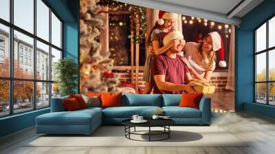 the family gives presents in a room with a christmas tree on christmas day. Wall mural