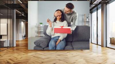 Valentine's day. A young couple gives a gift in a room Wall mural