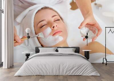 Woman in mask on face in spa beauty salon. Wall mural