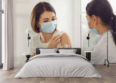 Young patient in a medical face mask getting an antiviral vaccine at the hospital Wall mural