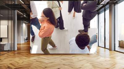 Young people meeting, interacting and making contacts at business event session. Group of multi ethnic participants standing in office and talking. High angle, overhead top view, above. Header, banner Wall mural