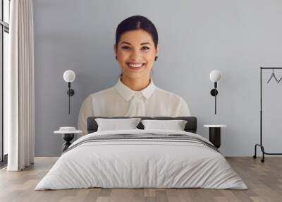 Young woman in white shirt smiling laughs joyful happy positive on a gray background. Wall mural