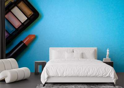 lipstick and colorful eye shadow palette on blue paper backgroun Wall mural