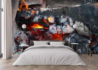 Glowing embers in hot red color, abstract background. The hot embers of burning wood log fire. Firewood burning on grill. Texture fire bonfire embers. Wall mural