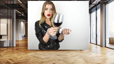 young beautiful blonde woman wearing black leather jacket drinks wine and being arrested and handcuffed on isolated white background Wall mural