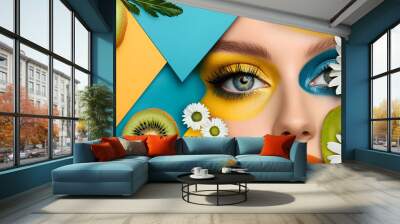 A vibrant collage featuring a closeup of a womans eye with bold colorful makeup in yellow and blue Surrounding elements include daisies kiwi slices abstract geometric shapes Wall mural