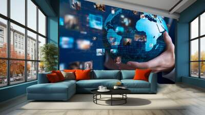 Hand holding a globe with various media images floating around it, symbolizing global digital marketing and advertising Wall mural