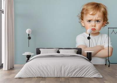 Mad male kid, angry little boy standing with his arms crossed, and looking at the camera with upset face expression. Unhappy toddler, studio shot, annoyed and frustrated child emotion Wall mural