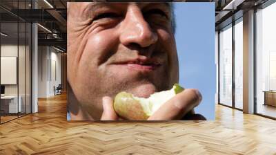 Mature man eating pear Wall mural