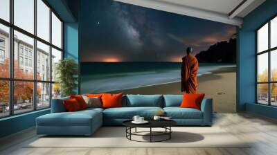 monk on a tranquil beach with starry sky, facing the ocean at night Wall mural