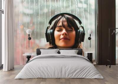 woman by the window, rain outside, wearing headphones with closed eyes Wall mural