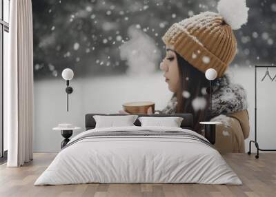 woman with a beanie holding a cup of coffee, steam rising, in snow Wall mural