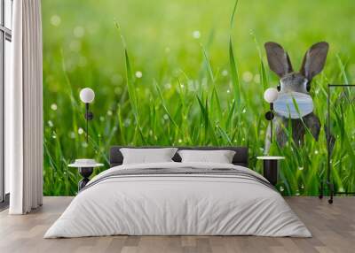 cute easter bunny with respiratory mask in green grass corona covid 19 protection Wall mural