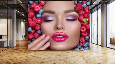 Beauty fashion model girl lying in fresh ripe fruits, berries and mint. Face in colorful berries close-up. Beautiful make-up, juicy and sexy lips, pink eyeshadows. Healthy eating concept, facial mask Wall mural