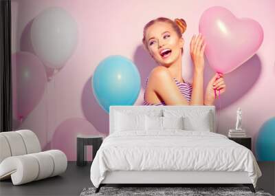 Beauty joyful teenage girl with colorful air balloons having fun over pink background Wall mural