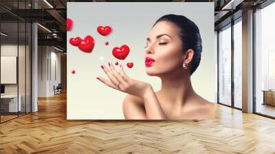 Beauty woman with perfect make up blowing valentine hearts Wall mural