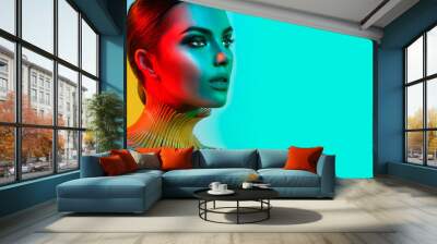 Fashion model woman in colorful bright lights posing. Portrait of beautiful sexy girl with trendy makeup Wall mural