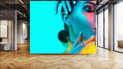 High Fashion model woman in colorful bright lights, portrait of beautiful sexy girl with trendy make-up and manicure. colorful neon skin, Art design, multicolor make up. Over blue background Wall mural