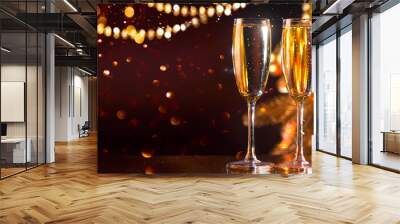 Holiday Champagne Flute over Golden glowing background. Christmas and New Year celebration. Two Flutes with Sparkling Wine over Holiday Bokeh Blinking Background. Table setting, decoration Wall mural