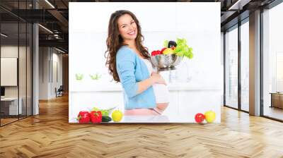 Pregnant young woman cooking vegetables. Healthy food Wall mural