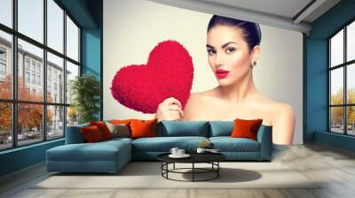 Sexy brunette woman holding heart shaped red pillow Wall mural