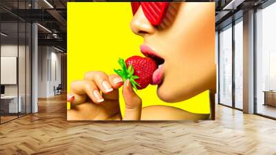 Sexy woman wearing red glamor sunglasses eating strawberry Wall mural