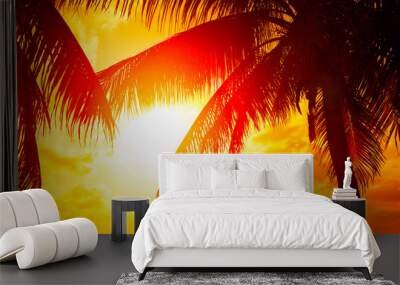 Sunset beach with palm trees and beautiful sky landscape. Beautiful coconut palms silhouettes over orange sun Wall mural