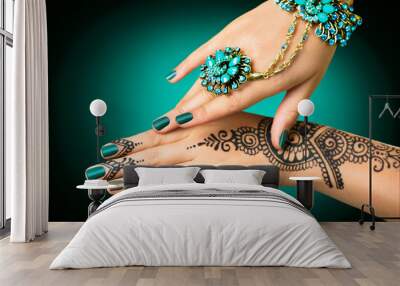 Woman's hands with mehndi tattoo. Hands of Indian bride girl with black henna tattoos Wall mural