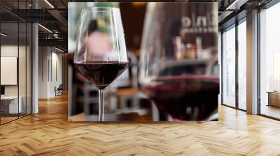 Close-up macro detail of a pair of red wine glasses, with foreground blur, at an expensive Italian restaurant. Food and drinks concept. Wall mural