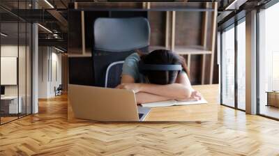 Tired Asian student girl lying on table in front of laptop, sleeping, taking break during online learning. Female freelancer napping at home office, feeling lazy to work remotely. Selective focus Wall mural