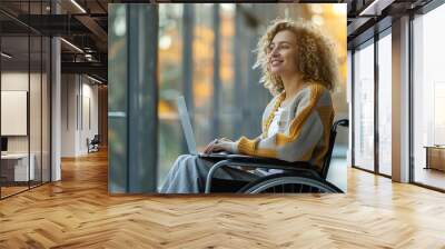 wide photo of cute woman in wheelchair using a laptop  Wall mural