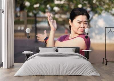 Asian  woman workout before fitness and  athletes training in the park. Wall mural