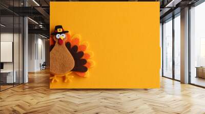 orange brown and yellow crafted felt turkey laying flat on an orange background with copy space	 Wall mural