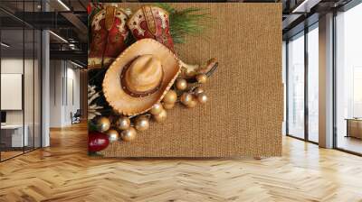 tan and brown cowboy boots and hat with pine, pine cone and berries on a tan textured background with copy space Wall mural