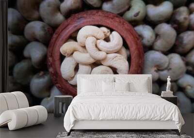 Cooked cashew nut in the wooden pot and cashew nut in background Wall mural