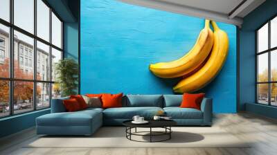 Two ripe bananas positioned on a vibrant blue background, bananas, fruit, yellow, healthy, snack, tropical, duo, vibrant, fresh Wall mural