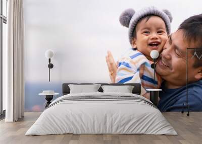 Asian father is playing with little baby boy with happiness moment on the background of nature , concept of trust love and bonding in family life. Wall mural