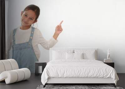 Isolated of happy and healthy 6 years old asian little girl is standing and pointing up on the white background. Concept of thinking, idea, expression, advertising, people, lifestyle. Wall mural