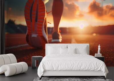 Focus on running shoe of athletic runner training in stadium at sunset, preparing for sports competition Wall mural