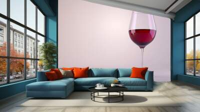 A glass of red wine stands alone against a plain white background Wall mural