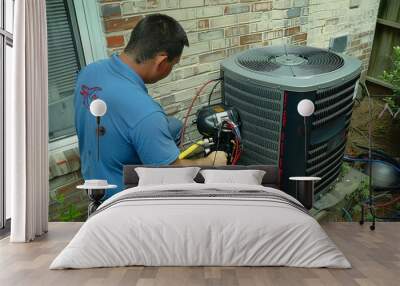 An air conditioning technician is getting ready to install a new air conditioner. They are using a vacuum pump to remove air and moisture from the new unit before installing it. Wall mural