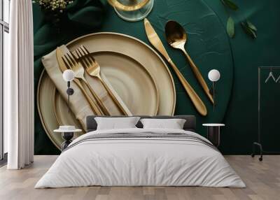 Elegant table setting with beige plates and gold cutlery on a dark green background. Use it as a card template or menu for a luxury restaurant. Top view. Wall mural