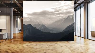 Nature aerial landscape view black and white photo of sunrise over snow capped Karakoram mountain range with morning fog in Nagar valley. Gilgit Baltistan, Pakistan. Wall mural