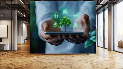 A professional holds a smartphone displaying a digital eco-friendly tree, symbolizing sustainable technology and growth. Wall mural