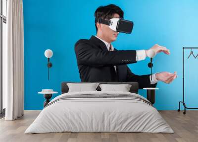 Asian businessman looking thorough VR try to zoom in or out with connecting business world report in futuristic metaverse analyzing innovation technology virtual reality blue copyspace. Contrivance. Wall mural