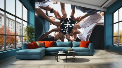 Below view of diverse corporate officer workers collaborate in office connecting puzzle pieces as partnership and teamwork concept. Unity and synergy in business idea by merging jigsaw puzzle. Concord Wall mural